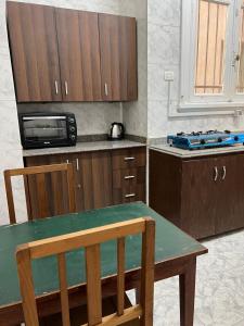 a kitchen with a table and a microwave at Homestay in Cairo