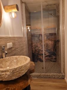 La salle de bains est pourvue d'un lavabo et d'une douche. dans l'établissement FeWo Todeskino ''Strandgut'' in Heiligenhafen, à Heiligenhafen