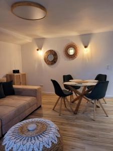 ein Wohnzimmer mit einem Sofa, einem Tisch und Stühlen in der Unterkunft FeWo Todeskino ''Strandgut'' in Heiligenhafen in Heiligenhafen