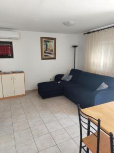 een woonkamer met een blauwe bank en een tafel bij Apartment Borik in Zadar