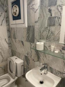 W łazience znajduje się umywalka, toaleta i lustro. w obiekcie Gulf grand hotelجلف جراند اوتيل w Kuwejcie