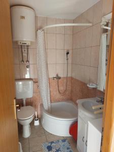 a bathroom with a toilet and a tub and a sink at Apartment Borik in Zadar