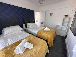 een hotelkamer met 2 bedden en handdoeken erop bij Boss Fab4 Stay &Garden Pro Host in Liverpool