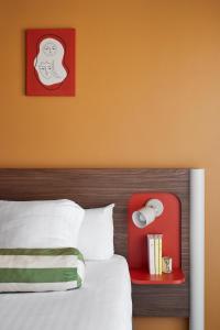 a bedroom with a bed with a red head board at Hotel Abrial in Cannes
