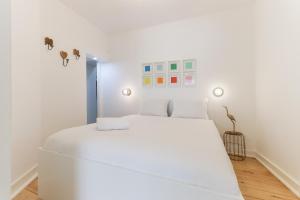 Un dormitorio blanco con una gran cama blanca. en Castelo Premium by Homing, en Lisboa