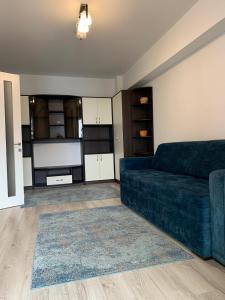 uma sala de estar com um sofá azul e um tapete em Luxury Studios & Apartments Newton by GLAM em Iaşi