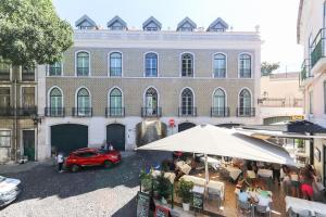 Un coche rojo aparcado delante de un edificio en Castelo Premium by Homing, en Lisboa