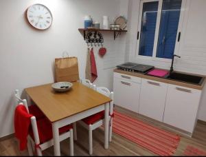 eine Küche mit einem Tisch, einem Tisch und einer Uhr in der Unterkunft Appartamento Nonno Pit, Marettimo in Marettimo