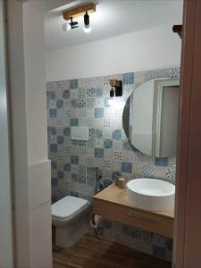 ein Badezimmer mit einem Waschbecken, einem WC und einem Spiegel in der Unterkunft Appartamento Nonno Pit, Marettimo in Marettimo
