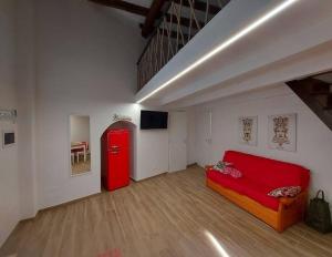 ein Wohnzimmer mit einem roten Sofa und einem roten Kühlschrank in der Unterkunft Appartamento Nonno Pit, Marettimo in Marettimo