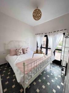 - une chambre avec un lit blanc et un lustre dans l'établissement Villa Sosaryca, piscine Bali, à Aït Ghemat
