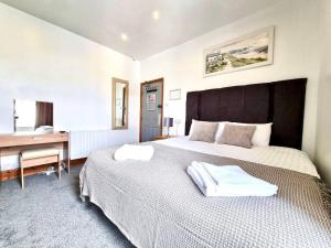 1 dormitorio con 1 cama grande y escritorio en Town Lodge en Newquay