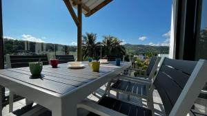 een tafel en stoelen op een balkon met uitzicht bij Résidence Autentik Garden in Bel Ombre