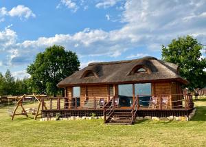 Cabaña de madera pequeña con techo de paja en Dreamland en Bodzentyn