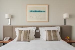 里斯本的住宿－多卡洛斯公園酒店，一张带两个枕头的床,上面有一张图