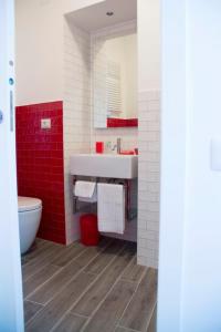 uma casa de banho com um lavatório branco e azulejos vermelhos em CalaLaNotte em Recanati