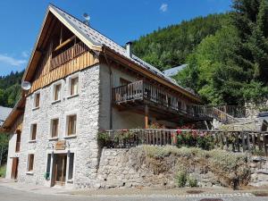 a large stone building with a balcony on it at Apartment Cascade 3 minutes from Alpe d Huez Grand Domaine via Oz en Oisans in Oz