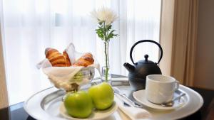 uma mesa com uma bandeja de pão e uma chávena de café em Puerto Norte Design Hotel em Rosário