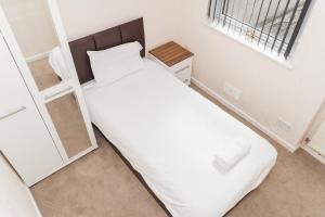 a bedroom with a large white bed and a window at City Rooms in Stoke City in Stoke on Trent