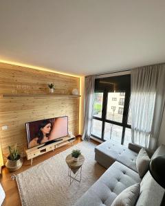 a living room with a couch and a flat screen tv at Precioso Piso en La Molina in La Molina