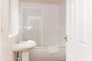 City Rooms in Stoke City في ستوك أون ترينت: حمام أبيض مع حوض وحوض استحمام