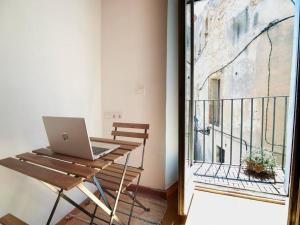 een laptop op een houten tafel naast een balkon bij Cal Jueu. Casa original. in Tarragona
