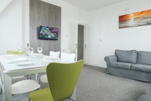 a dining room with a white table and a couch at Farina Holiday apartments in Bridlington