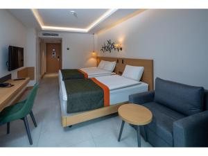 a hotel room with a bed and a couch at Swandor Hotels & Resorts - Kemer in Kemer