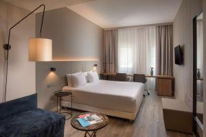 a hotel room with a bed and a couch at NH Trieste in Trieste