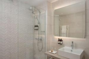 ein Bad mit einer Dusche und einem Waschbecken in der Unterkunft NH Trieste in Triest
