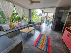 Juliet Home Samui في Ban Lamai: غرفة معيشة مع أريكة وطاولة