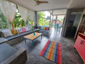 a living room with a couch and a table at Juliet Home Samui in Ban Lamai