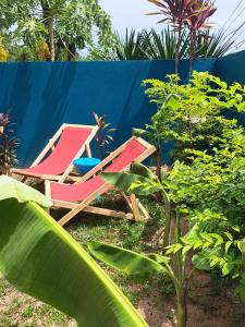 a group of lounge chairs sitting next to a fence at Juliet Home Samui in Ban Lamai