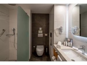 a bathroom with a toilet and a sink and a mirror at Swandor Hotels & Resorts - Kemer in Kemer