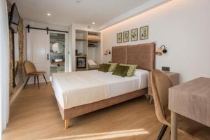 a bedroom with a large bed and a table at O Relax do Río - Casa Molino Boutique, con Jardín y Desayuno en Muxía in Muxia