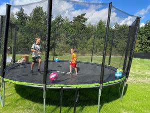 dwóch młodych chłopców bawiących się na trampolinie w obiekcie Sun House 