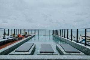 a swimming pool with a view of the ocean at Flats na praia do Bessa in João Pessoa