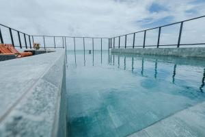 a swimming pool with the ocean in the background at Flats na praia do Bessa in João Pessoa