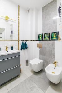 La salle de bains est pourvue de toilettes blanches et d'un lavabo. dans l'établissement Zielono Mi, à Słupsk