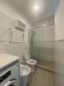 a white bathroom with a toilet and a shower at Casa Isabel in Cuneo