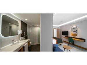 a bathroom with a sink and a mirror and a bedroom at Swandor Hotels & Resorts - Kemer in Kemer