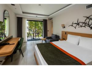 a hotel room with a bed and a desk and a room at Swandor Hotels & Resorts - Kemer in Kemer