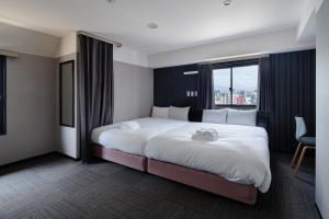 福岡市にあるホテル スターライズの大きなベッドと窓のあるホテルの部屋