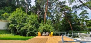 une terrasse avec une table, des chaises et des arbres dans l'établissement Pine Forest Apartments, à Braşov
