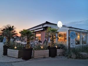 un ristorante con palme di fronte a un edificio di Offizier 18 a Neustadt in Holstein