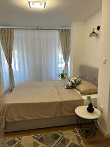 a bedroom with a large bed and a table at Cluj Home due in Cluj-Napoca