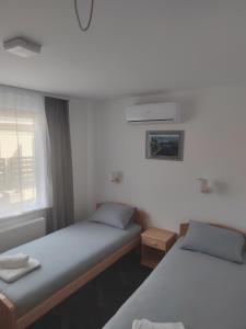 a room with two beds and a window at APARTMANI VALJEVO in Valjevo