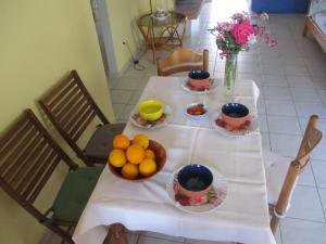 a table with plates of fruit on top of it at Anna's Sweet Home Akrata in Paralía Akrátas