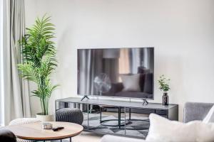 a living room with a large television on a wall at GuestReady - Olympic Park City Living in London