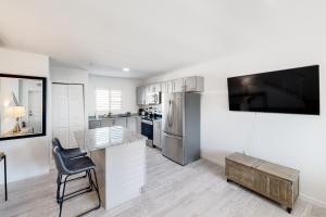 a kitchen with white cabinets and a large tv at Green Pineapple in Marathon
